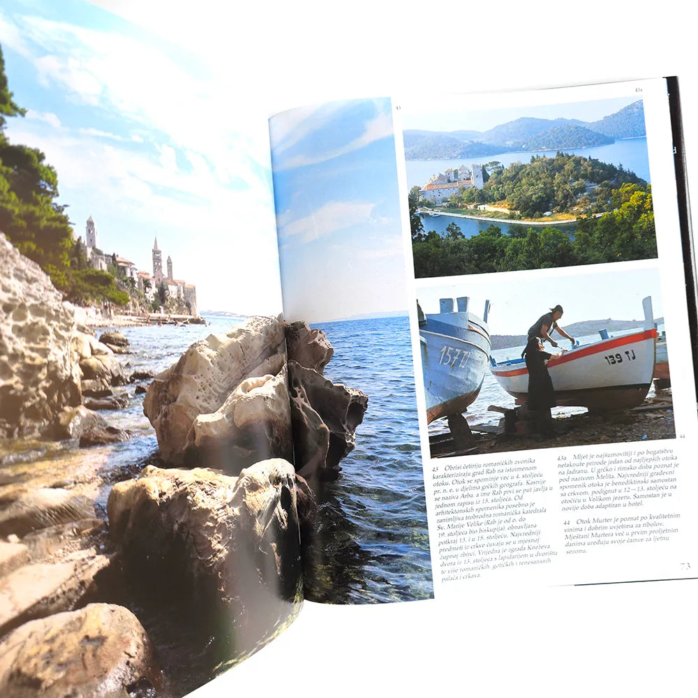 Hrvatska - Photographic Monograph Open magazine showing a scenic coastal view with boats and a person.