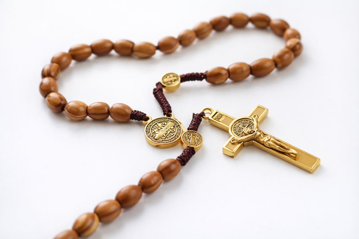 Wooden rosary with gold crucifix and medal on a white background