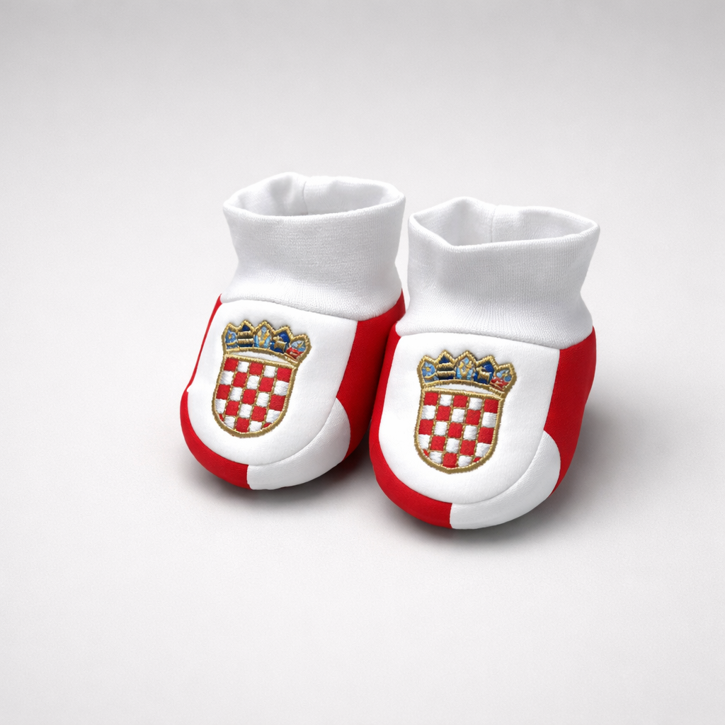 Baby Slippers Croatia Checks White baby booties with red accents and a crest design on a white background