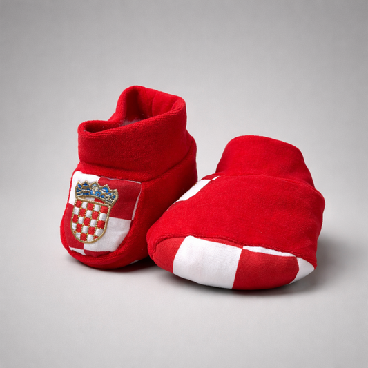 Baby Slippers Croatia in Red Red baby booties with a crest design on a gray background