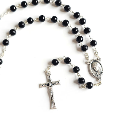 Black Catholic Rosary – Silver Crucifix & Marian Medal Black rosary beads with a silver cross and medal on a white background