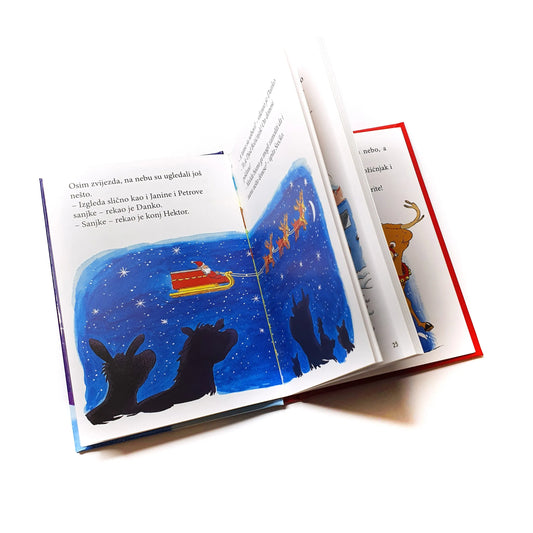 Božićne Priče Open book with a Christmas illustration of Santa Claus in a sleigh.