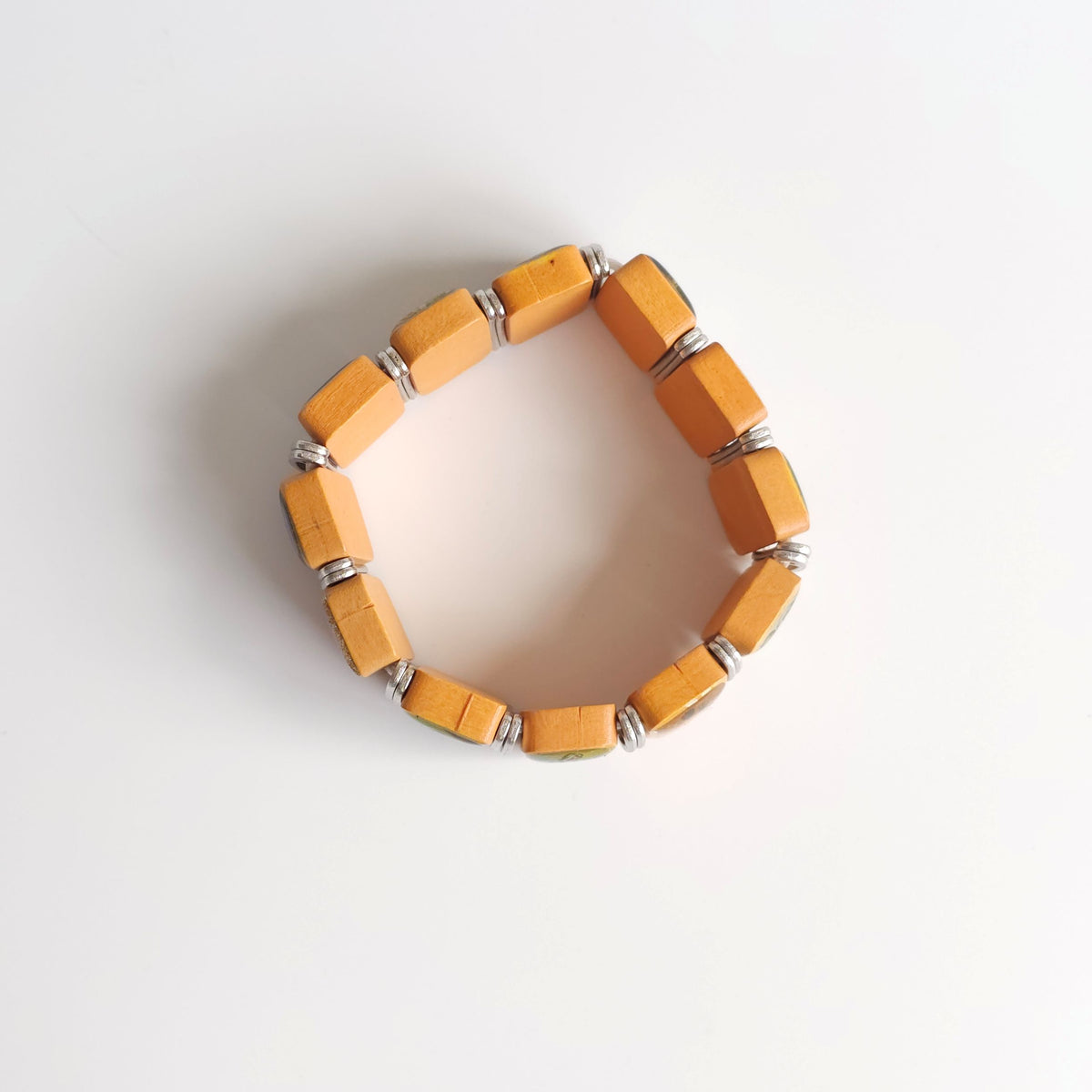Bracelet Međugorje in Oak (Flat Spacer) Yellow beaded bracelet on a light gray background