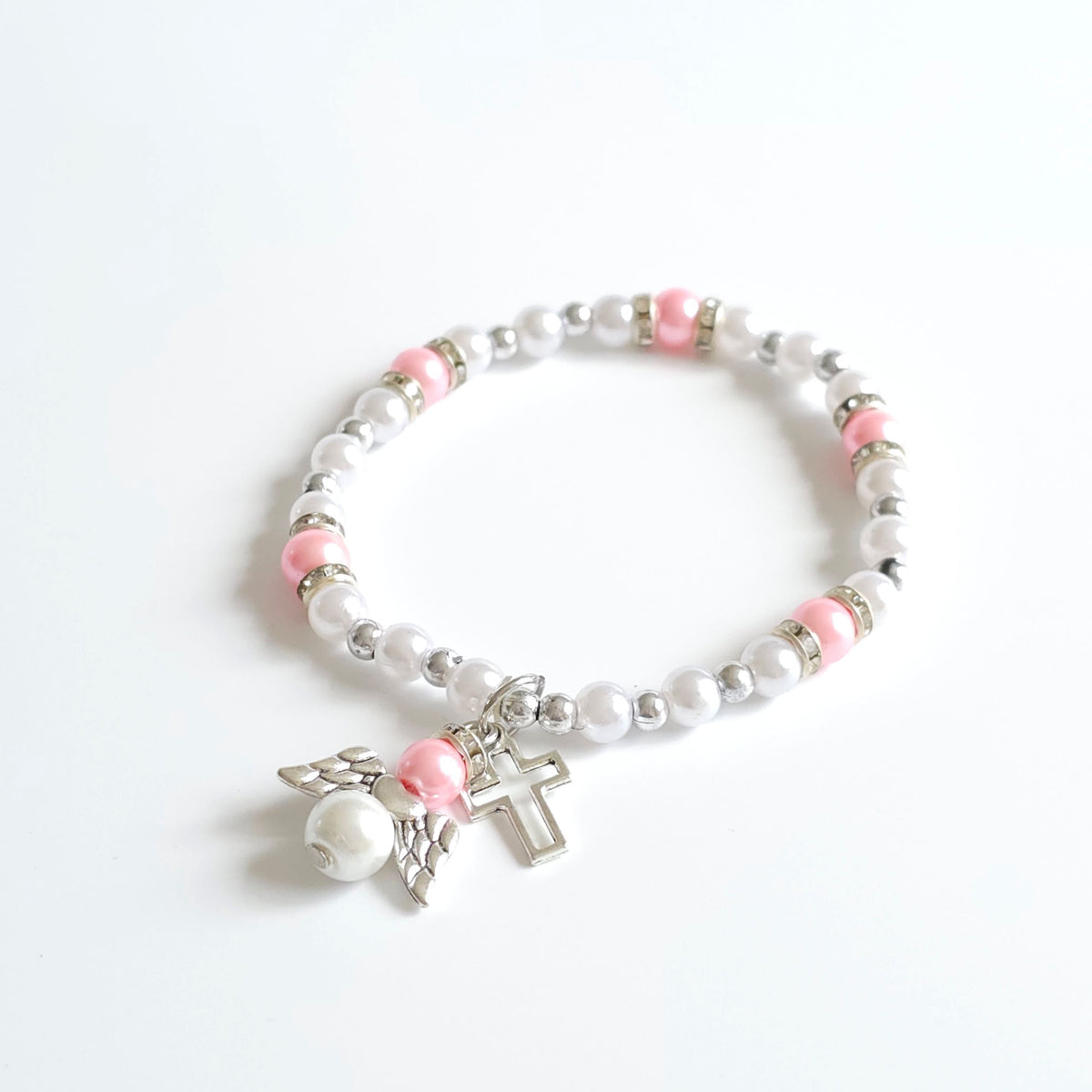 Bracelet Pink & White Angel Cross Bracelet with white beads, pink accents, and a silver cross charm on a white background