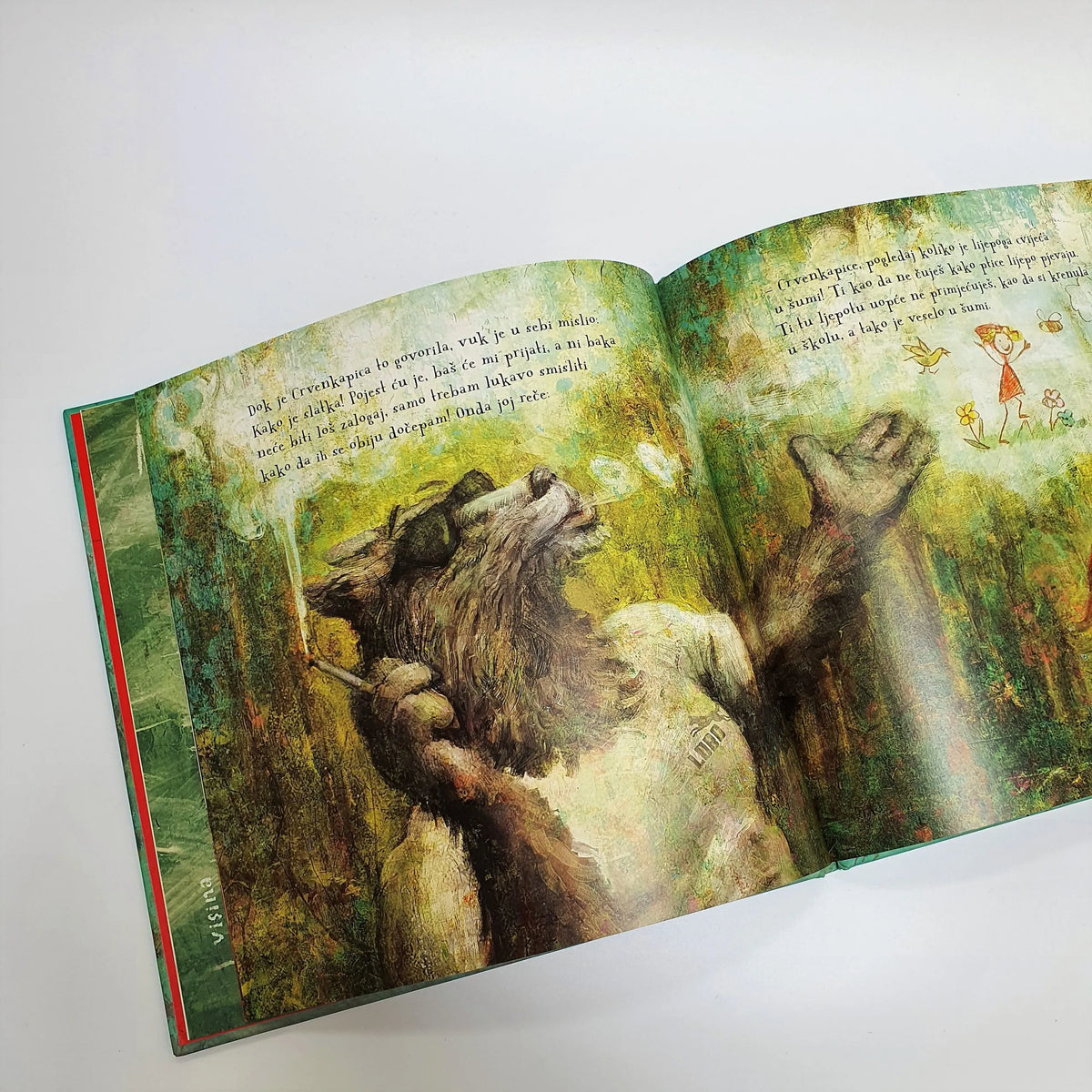 CRVENKAPICA (2020) Open book with illustrations of a wolf and a bear in a forest setting on a white background.