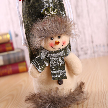 Christmas Bottle Cover – Santa, Snowman & Reindeer Decorative snowman figurine with a scarf and fur trim on a wooden surface.