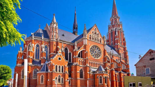Fortress Churches in Croatia (English) Gothic-style church with red brick facade under a clear blue sky
