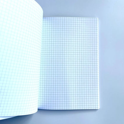 GNK Dinamo A5 Writing Book / Note Pad Open notebook with grid paper on a light blue background