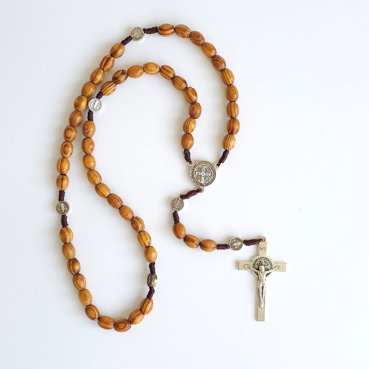 Wooden rosary with a cross on a white background