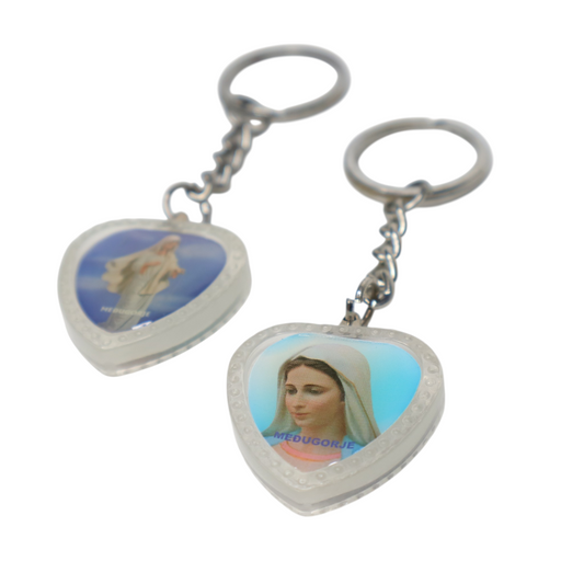 Heart-Shaped Catholic Keyring - Virgin Mary of Medjugorje Heart-shaped keychain with images of a dove and a religious figure on a white background