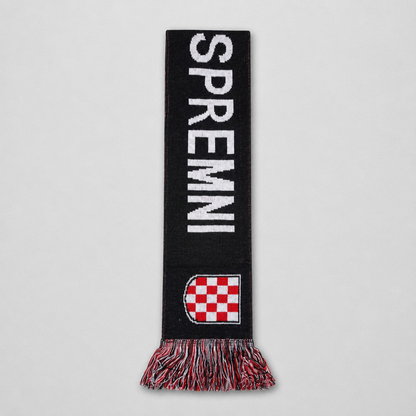 A black knit scarf with 'SPREMI' in bold white letters, a red and white checkered shield near the bottom, and multicolor fringe, shown flat against a light gray background. Knitted Scarf HOS Za Dom Spremni shopncro.live