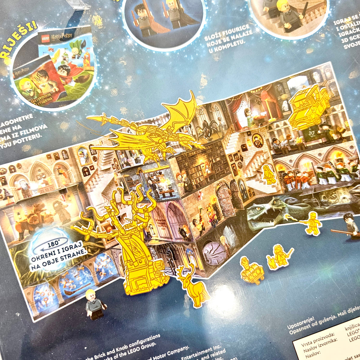 Lego Harry Potter- Potter Protiv Malfoyja Board game packaging with dragon and castle illustrations on a blue background