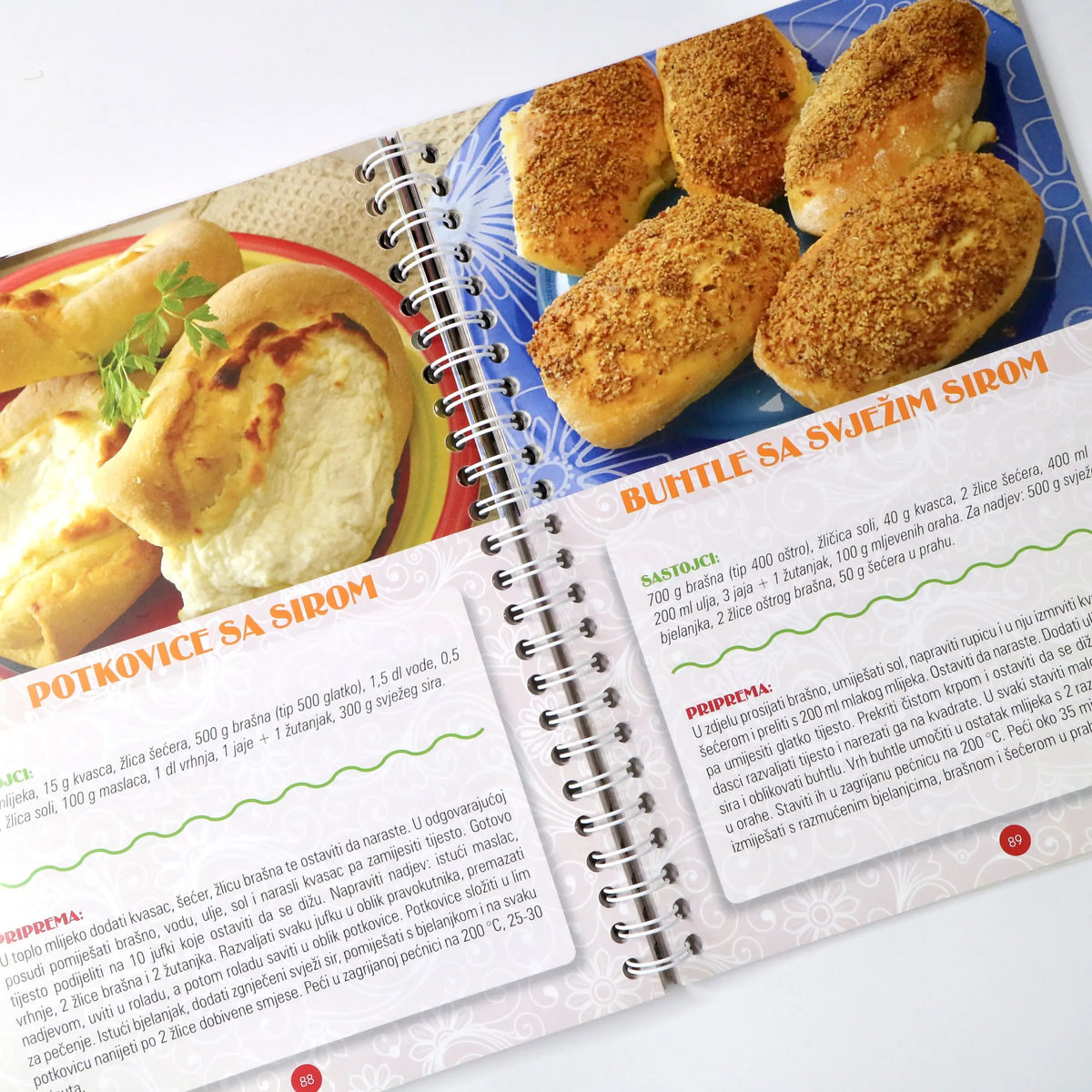 NAJBOLJI DOMAĆI KOLAČI 2 Open cookbook showing a recipe for potkovic with images of bread and cheese on a white background