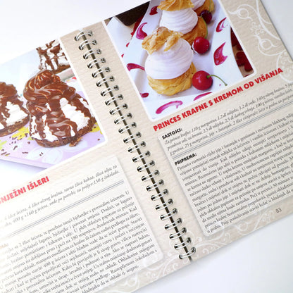 NAJBOLJI DOMAĆI KOLAČI Open cookbook with dessert recipes and images on a white background