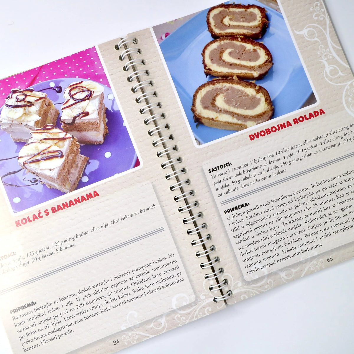 NAJBOLJI DOMAĆI KOLAČI Open cookbook showing pages with cake pictures and recipes