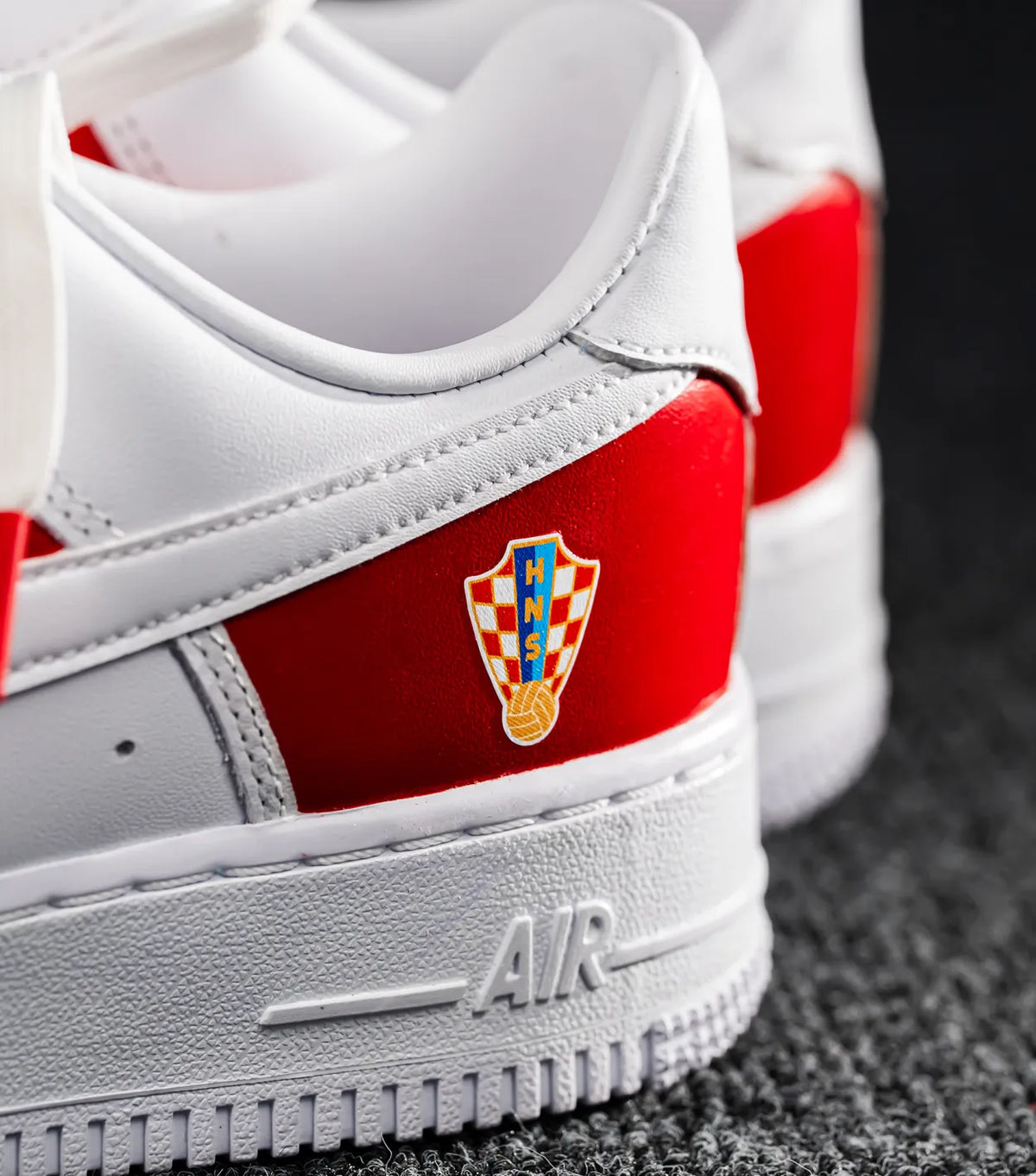 Nike Air Force 1 CROATIA HNS White sneaker with red accents and a logo on a dark surface shopncro