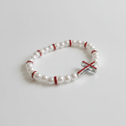 Red & White Cross Bracelet – Handmade Elastic Beaded Jewelry White beaded bracelet with red accents and a silver cross charm on a white background