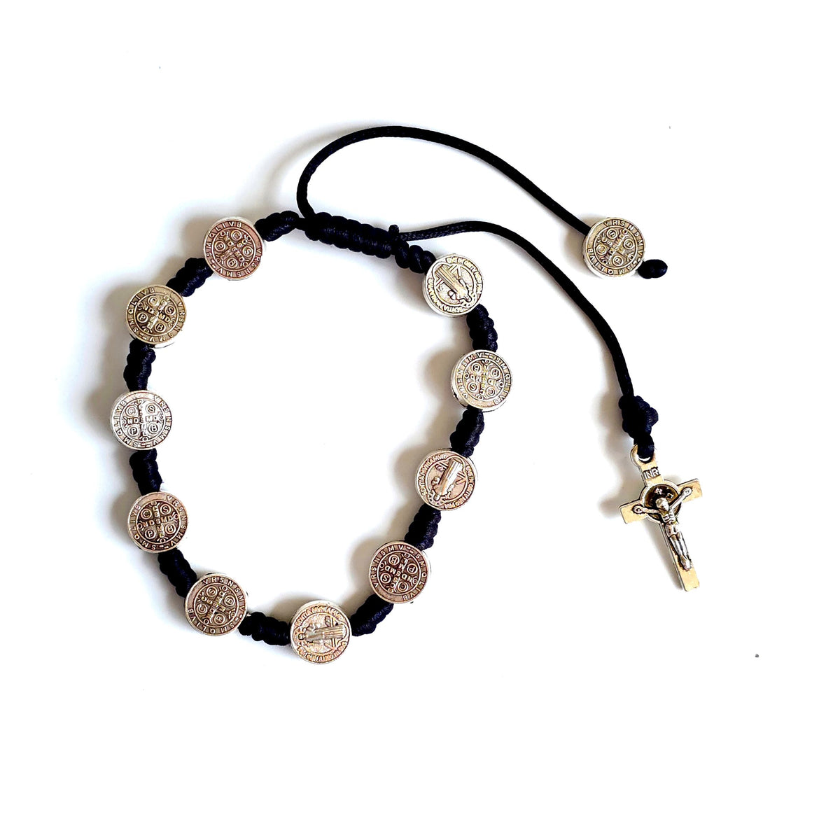 Saint Benedict Adjustable Bracelet with Cross (Black) Black cord bracelet with metal coins and a cross on a white background