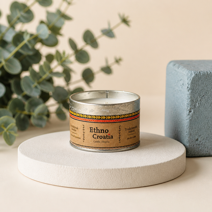 Scented Candle – Traditional Cookie (Ethno Croatia) Candle in a metal tin labeled 'Ethno Croatia' on a white surface with a plant and blue cube in the background.