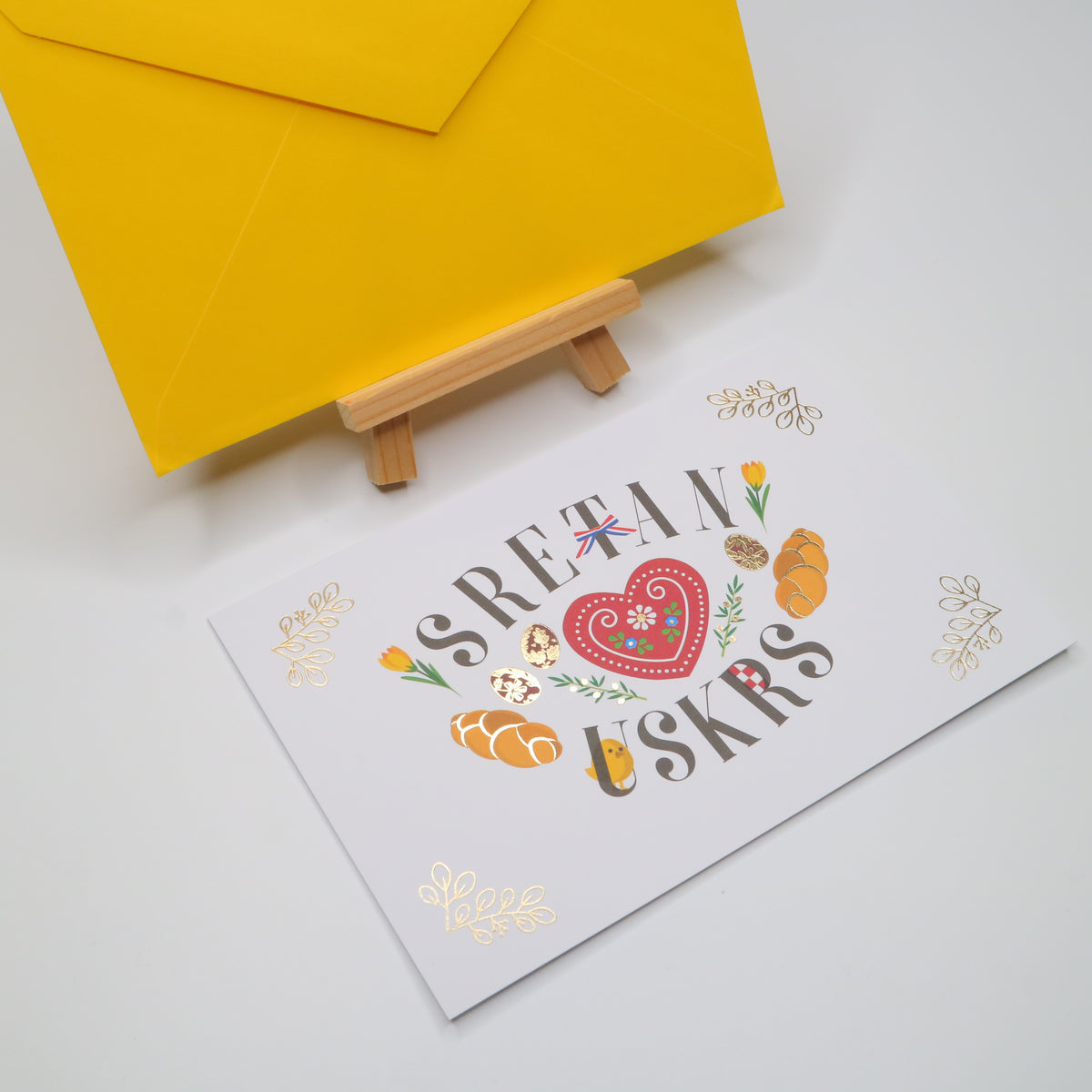 Sretan Uskrs Licitar Easter Greeting Card Greeting card with 'Sretav Uskrs' text and decorative elements on a white background with a yellow envelope.