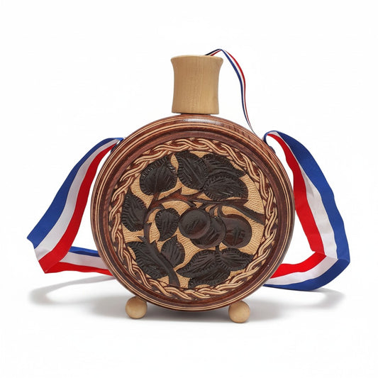 Wooden decorative item with engraved design and ribbons on a white background